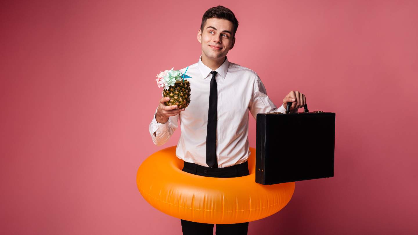 16-smart-ways-to-manage-your-tech-teams-vacation-schedules Man in shirt and tie holding a brief case and tropical drink while in an inner-tube.