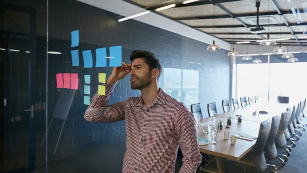 3 Big Mistakes to Avoid When Writing User Stories Man in front of the glass board seeing mistake in the process