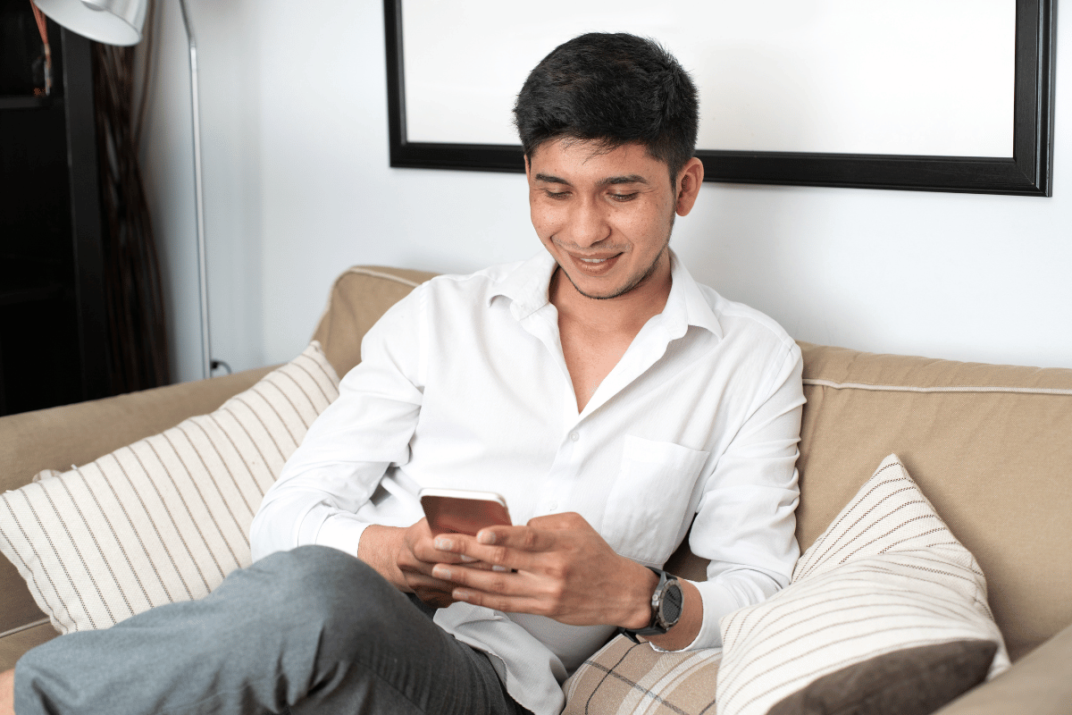 man smiling looking at mobile phone