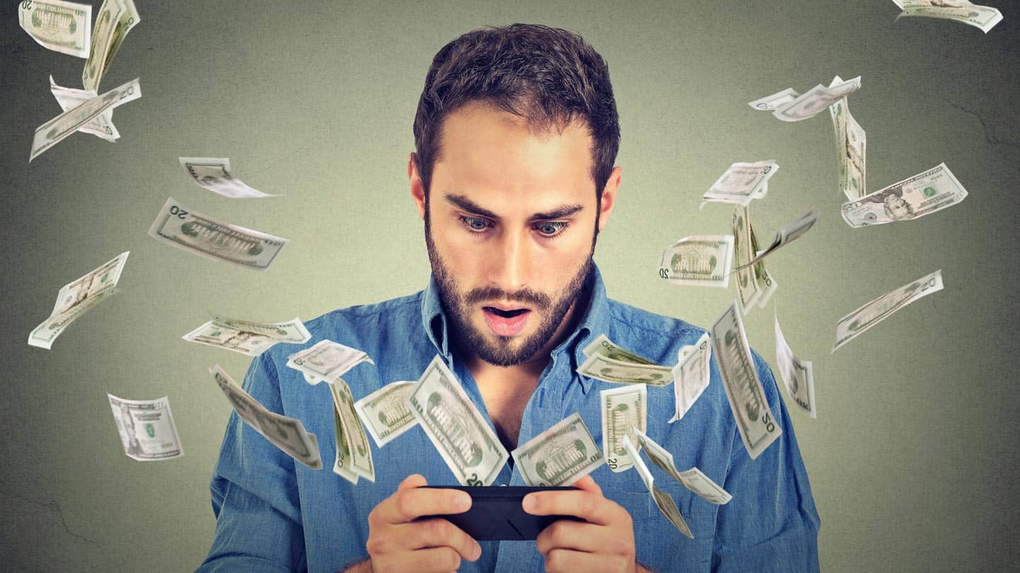 How to increase revenues with your app Male shocked with the money flying out of mobile device